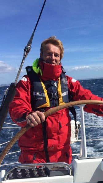 Pieter Brinkman aan dek in offshore-zeilkleding tijdens het varen